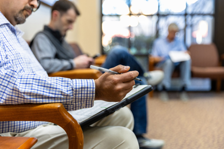 Patients checking in a waiting room at the hospital sitting