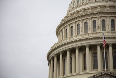 Close-up view of the US Capitol building's dome on a cloudy day.