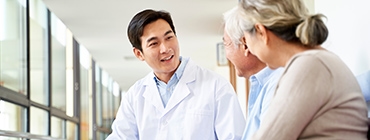 A friendly doctor talks with elderly patients. This approachable image is perfect for a healthcare or senior living website.
